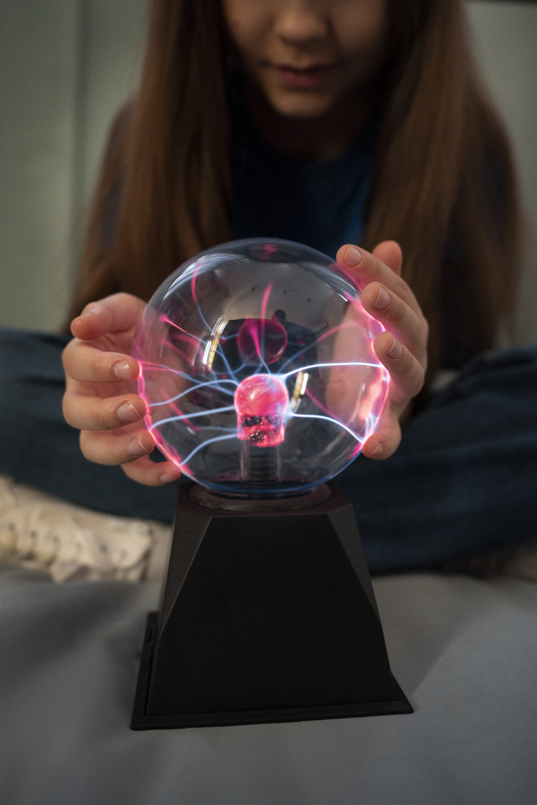 front view girl interacting with plasma ball